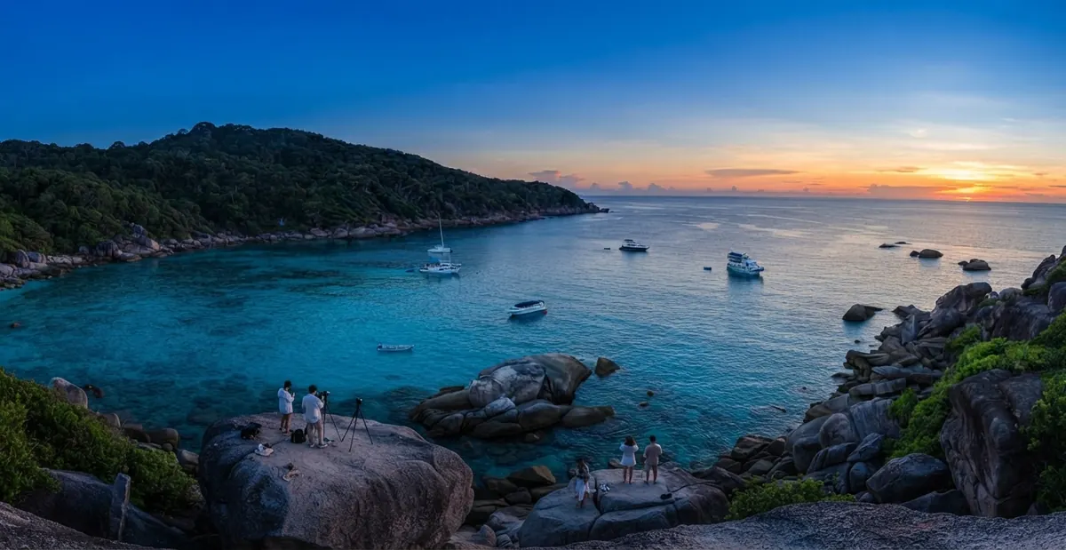 Boats anchored in a Similan bay at blue hour seen from a granite headland