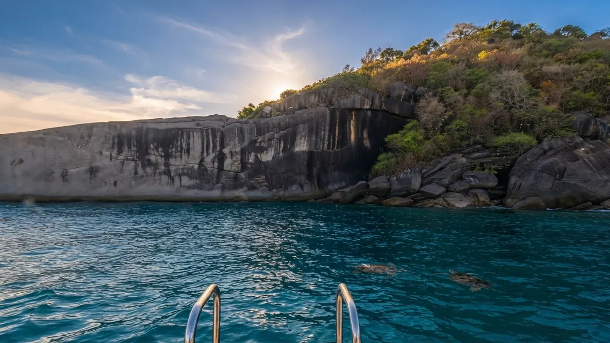 Boat ladder over deep blue water facing a sheer granite headland