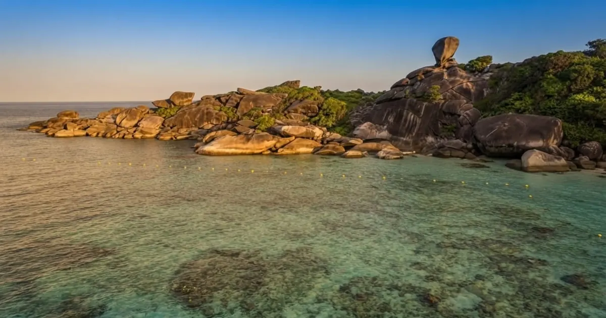 Low granite island over a shallow reef at sunset