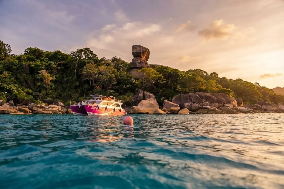 Pink speedboat near Sail Rock at golden hour, seen from water level