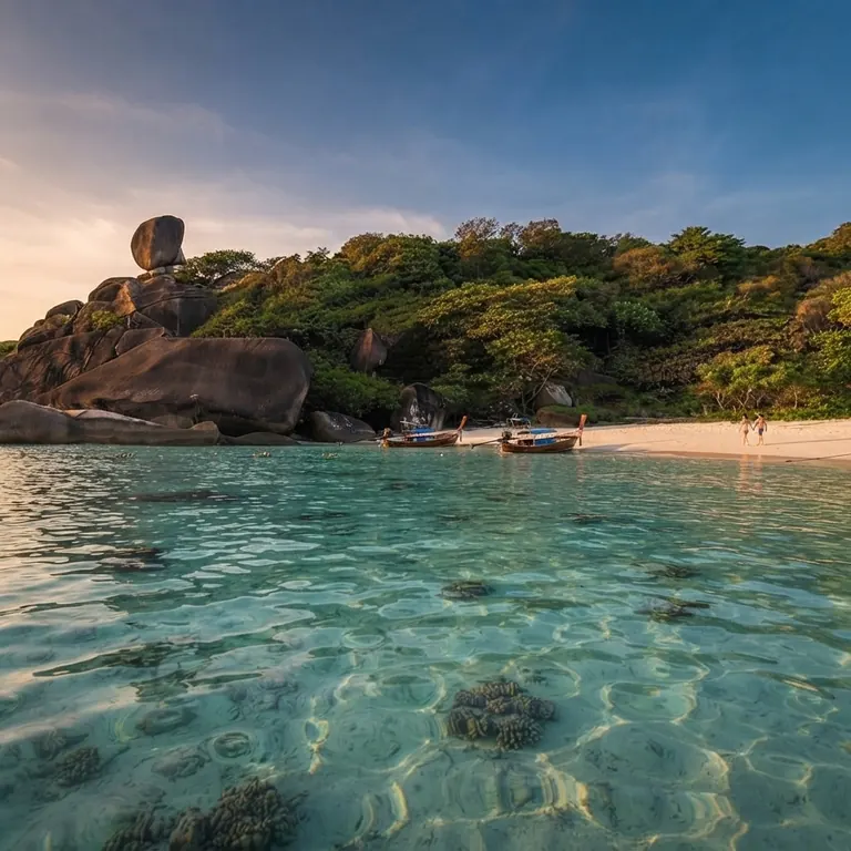 Sail Rock above a beach with crystal-clear shallow water and boats offshore