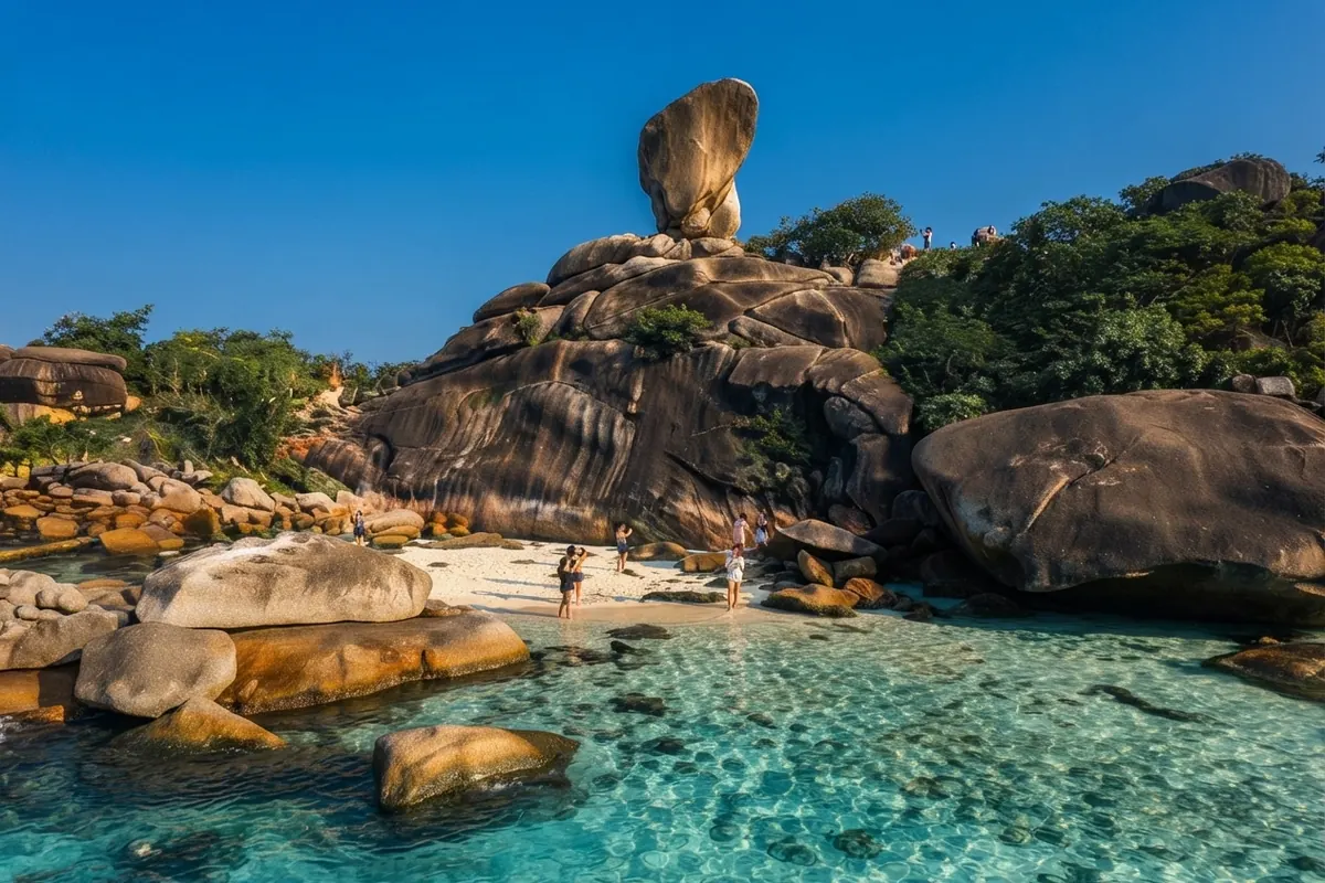 Sail Rock above boulder-strewn turquoise shallows in midday light