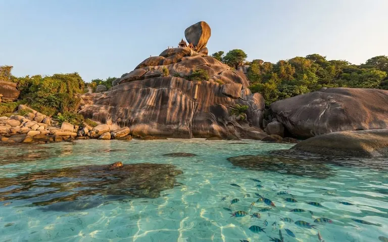 Sail Rock above crystal-clear shallows with fish and coral visible from the surface